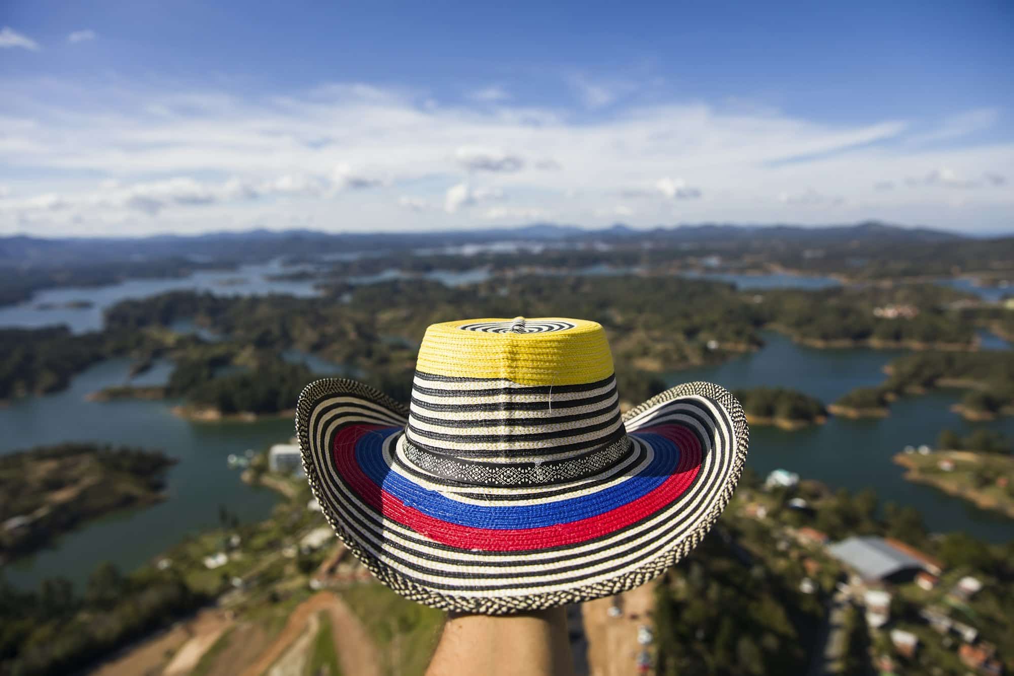 Hand with Colombian hat over Guatape lake in Antioquia, Colombia